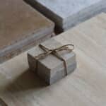 Próbki trawertyn Silver Latte 3cm Szlifowany o wymiarach 10x10 cm, ułożone jedna na drugiej i związane sznurkiem.